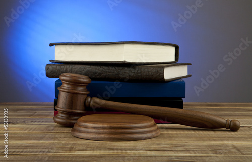 Photo: wooden mallet and books on a blue background wooden mallet and books on a blue background