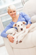 Woman sitting with young dog on the sofa