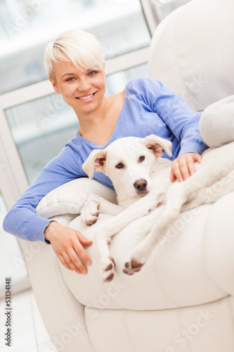 Photo: Woman sitting with young dog on the sofa Woman sitting with young dog on the sofa