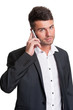Young business man with open collar talks on mobile phone