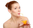 young woman drinking orange juice straight from fruit