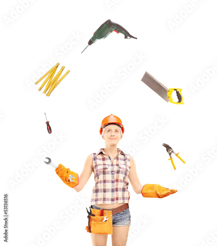 Photo: Female manual worker juggling with tools Female manual worker juggling with tools