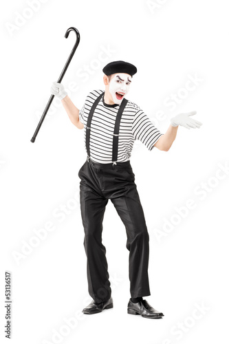 Photo: Full length portrait of a mime artist holding a cane and gesturi Full length portrait of a mime artist holding a cane and gesturi
