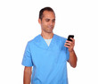 Foto: Smiling young nurse sending message on cellphone Smiling young nurse sending message on cellphone