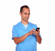 Foto: Smiling boy nurse sending message on cellphone Smiling boy nurse sending message on cellphone