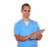 Foto: Young male in nurse uniform using tablet pc Young male in nurse uniform using tablet pc