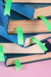 Many books with bookmarks on pink background close-up