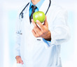 Doctor's hand holding a fresh green apple close-up