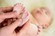 male hands massaging small baby feet