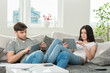 couple sitting on a couch with tablet computers