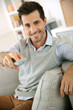 Foto: Smiling young man watching tv Smiling young man watching tv