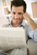 Photo: Man at home reading newspaper Man at home reading newspaper