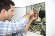 Foto: Electrician fixing cable in domestic electrical box Electrician fixing cable in domestic electrical box