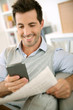 Photo: Man reading news on both paper and internet Man reading news on both paper and internet