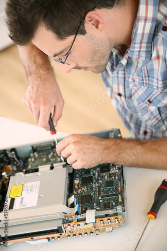 Photo: Man fixing electronic appliance Man fixing electronic appliance