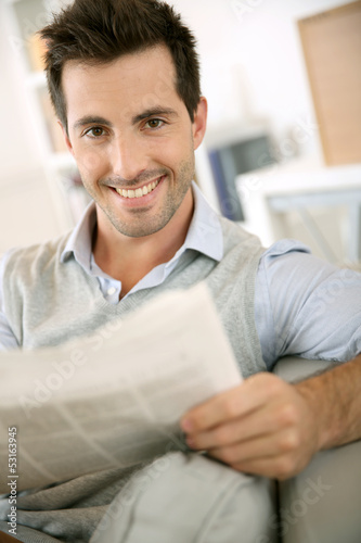 Photo: Man at home reading newspaper Man at home reading newspaper