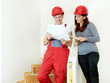 Young couple check the plan of their building lot