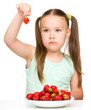 Photo: Little girl is eating strawberries Little girl is eating strawberries