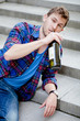 Drunk man drinking wine on the stairs and smoking cigarette