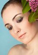 Portrait of beautiful woman with makeup and branch of lilac