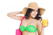 brunette girl in green swimsuit and hat, holding glass of orange