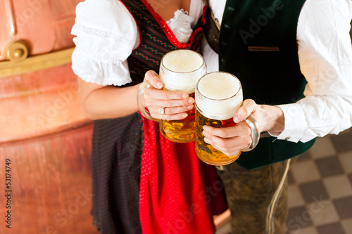 Photo: Man and woman with beer glass in brewery Man and woman with beer glass in brewery