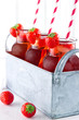 Strawberry juice with frozen icecubes and straws