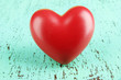 Decorative red heart on color wooden background