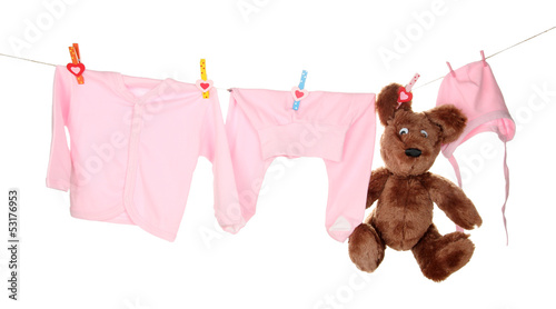 Photo: Baby clothes hanging on clothesline, isolated on white Baby clothes hanging on clothesline, isolated on white
