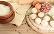 Raw dumplings, ingredients and dough, on wooden table
