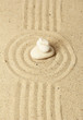 Zen garden with raked sand and round stones close up