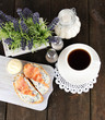 Photo: Fish sandwiches and cup of tea on cutting board on wooden table Fish sandwiches and cup of tea on cutting board on wooden table