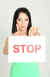 Girl showing stop sign on grey background