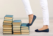 Girl climbs up on pile of books