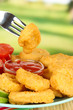 Fried chicken nuggets with vegetables and sauce on table in