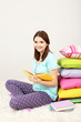Foto: Beautiful young girl with pillows and books in room Beautiful young girl with pillows and books in room