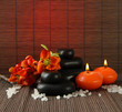 Spa stones with flowers and candles on bamboo background