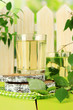 Glasses of birch sap on green wooden table