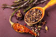 Various spices and herbs in a wooden spoon