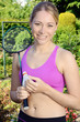 Junge Frau im Garten mit Badminton-Schläger und Federball