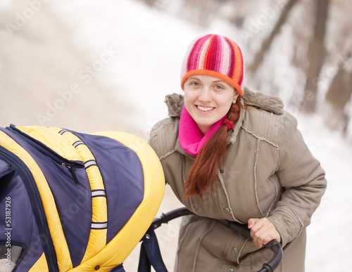 Photo: woman with pram in winter woman with pram in winter