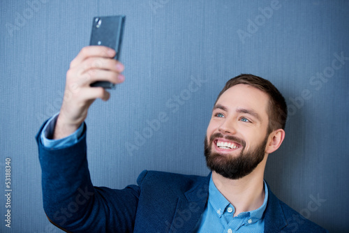 Photo: mann schaut auf sein smartphone mann schaut auf sein smartphone