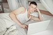 Man lying in bed with his laptop