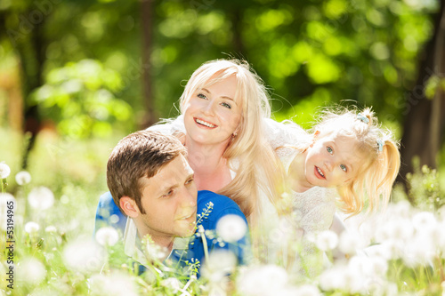 Photo: Happy mother, father and daughter in the park Happy mother, father and daughter in the park