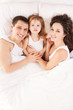 Happy family, mother, father and daughter resting on the white b