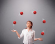 young girl standing and juggling with red balls