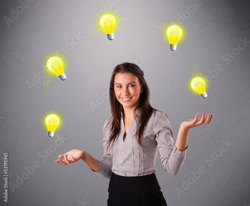 Photo: young lady standing and juggling with light bulbs young lady standing and juggling with light bulbs