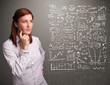 Photo: Pretty woman looking at stock market graphs and symbols Pretty woman looking at stock market graphs and symbols