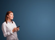 Photo: Young woman standing and typing on her phone with copy space Young woman standing and typing on her phone with copy space