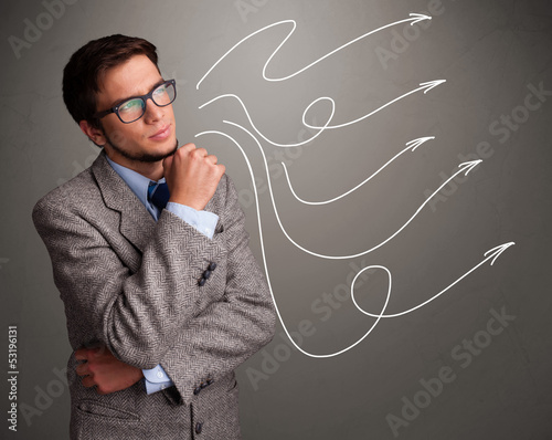 Photo: Attractive man looking at multiple curly arrows Attractive man looking at multiple curly arrows